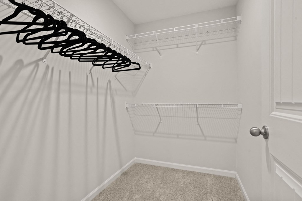 an empty closet with white walls and white curtains and a white closet door with shelves