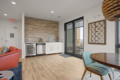 A modern kitchen with a wooden wall and a dining table with chairs.
