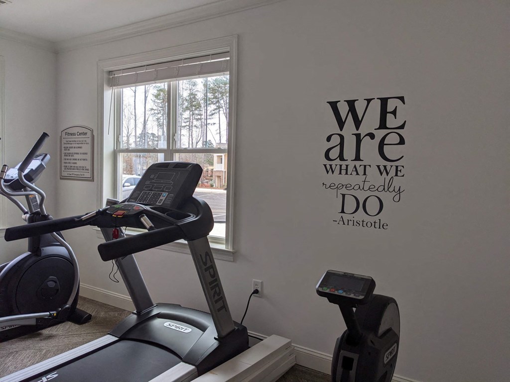 a gym with a exercise bike in a room with a window