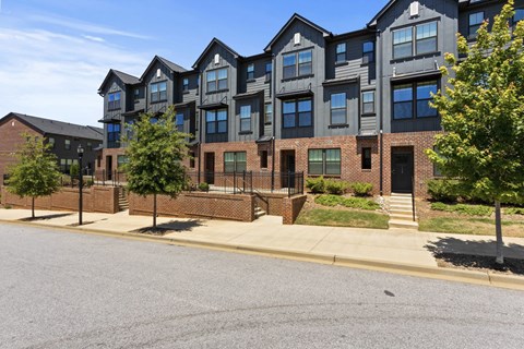 A large brick building with a black roof and a black fence.