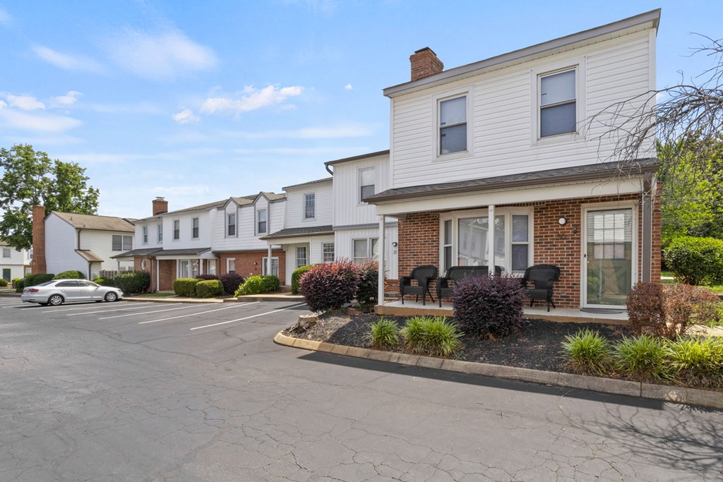 A row of houses with a car parked in front of them.