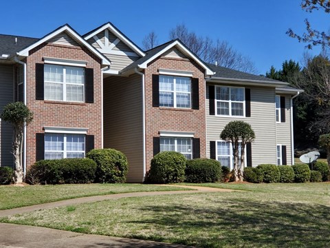 a large brick house with a sidewalk in front of it