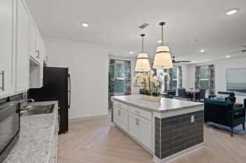 A modern kitchen with a black refrigerator and a marble countertop.