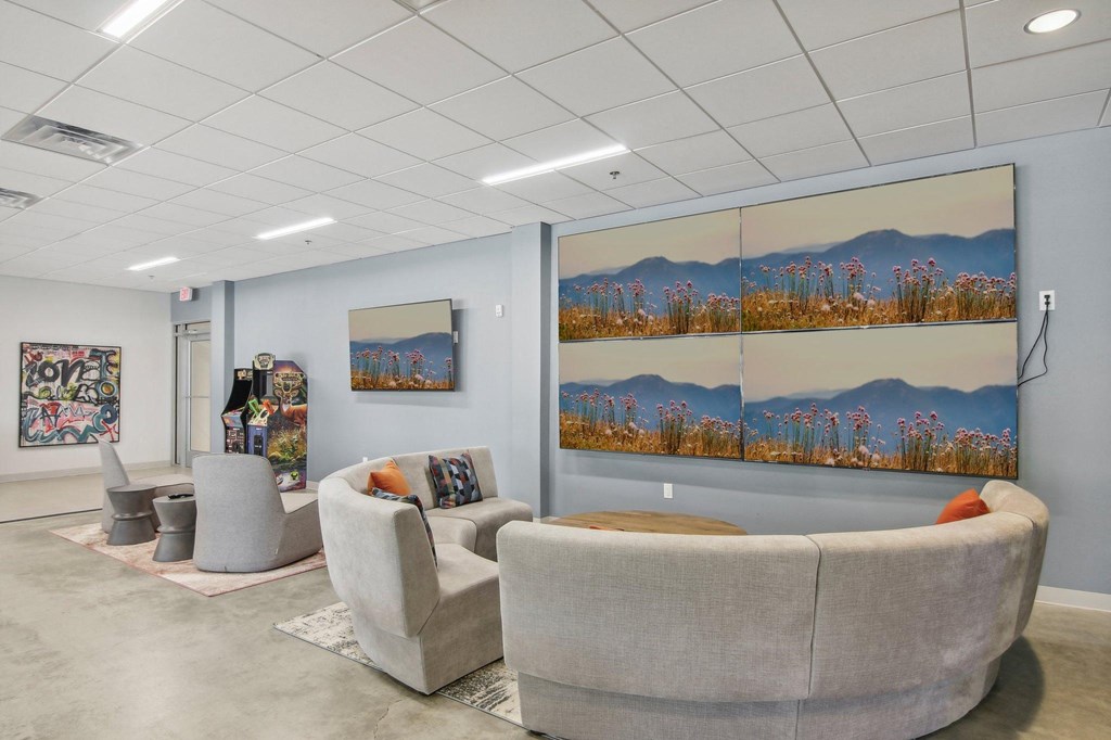 a waiting room with couches and chairs and paintings on the wall