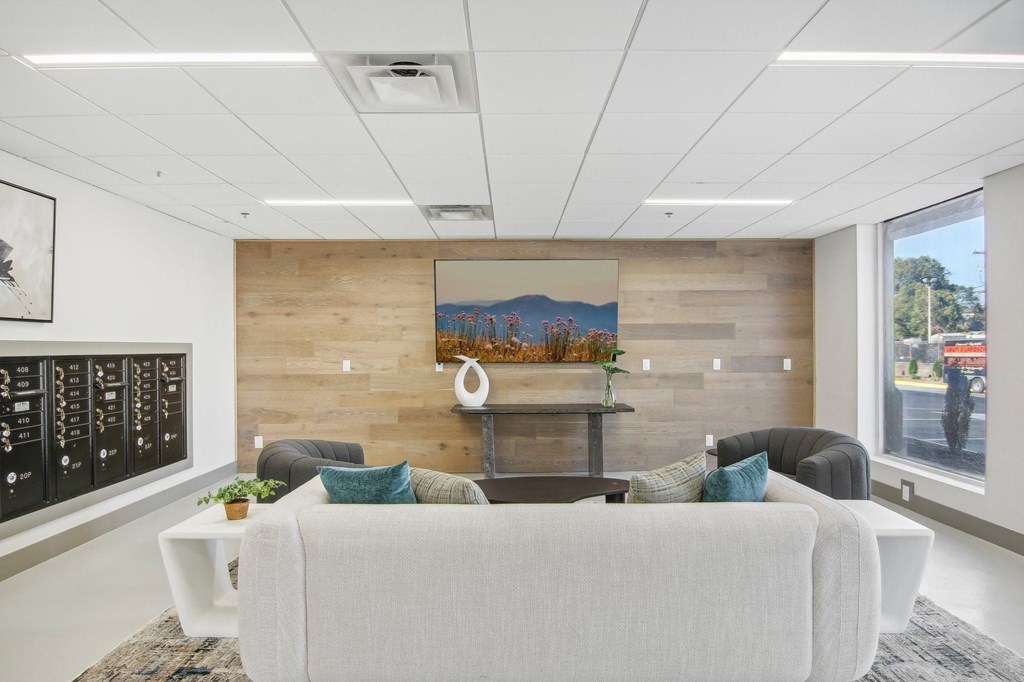 a living room with a couch and a table in front of a wooden wall