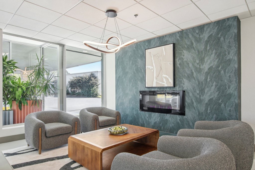 a living room with chairs and a table and a fireplace