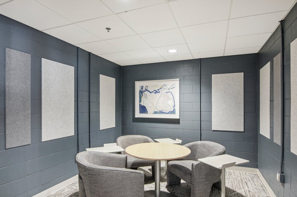 a meeting room with chairs and tables and a painting on the wall