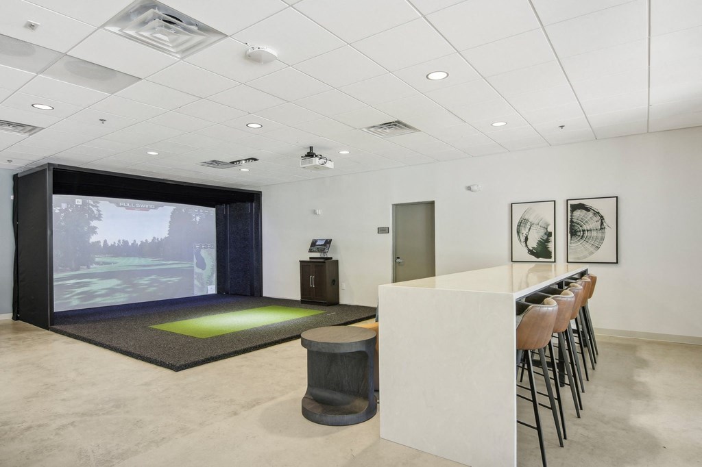 a room with a bar and a projection screen on the wall