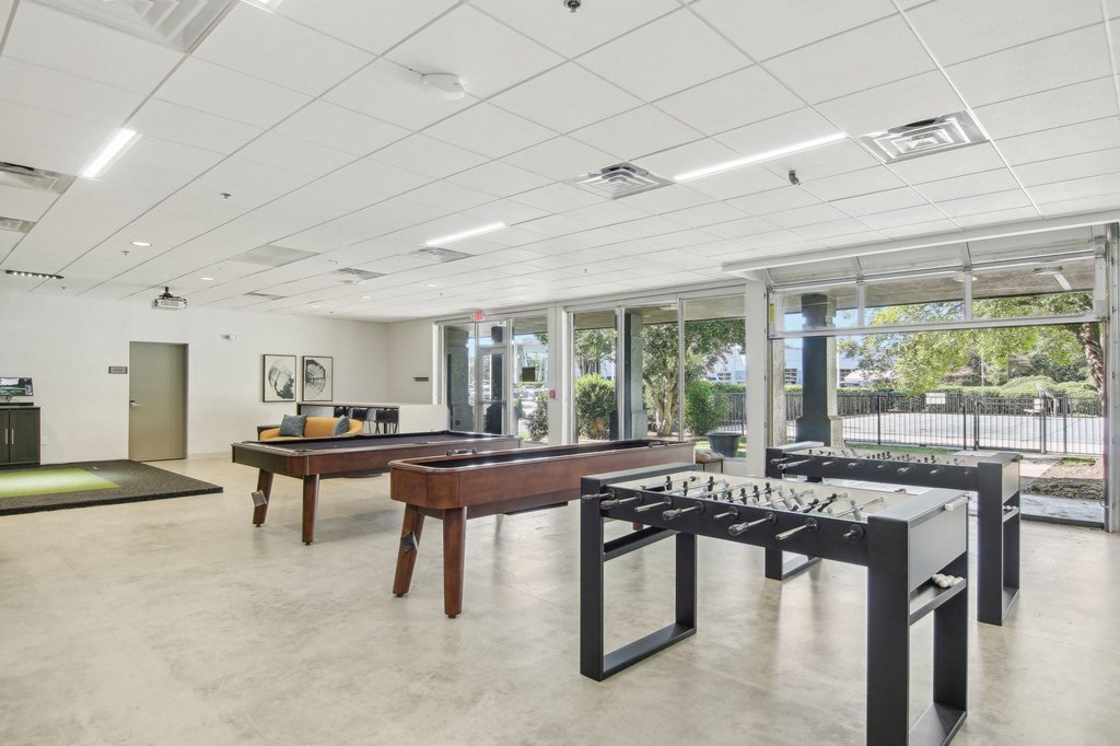 1 Bedroom Apartments in Greenville, SC | Flathouse Studios | Gaming Lounge with Foosball, Shuffleboard, Billiards, and Full Swing Golf Simulator.