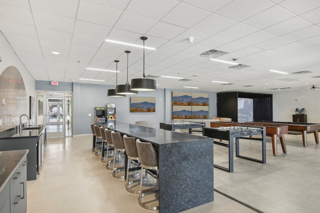 1 Bedroom Apartments in Greenville, SC | Flathouse Studios | Gaming Lounge with Foosball, Shuffleboard, Billiards, and Full Swing Golf Simulator.