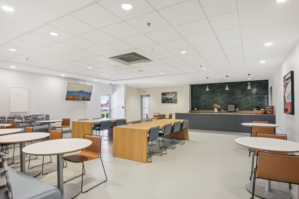 a dining room with tables and chairs and a blackboard in a classroom