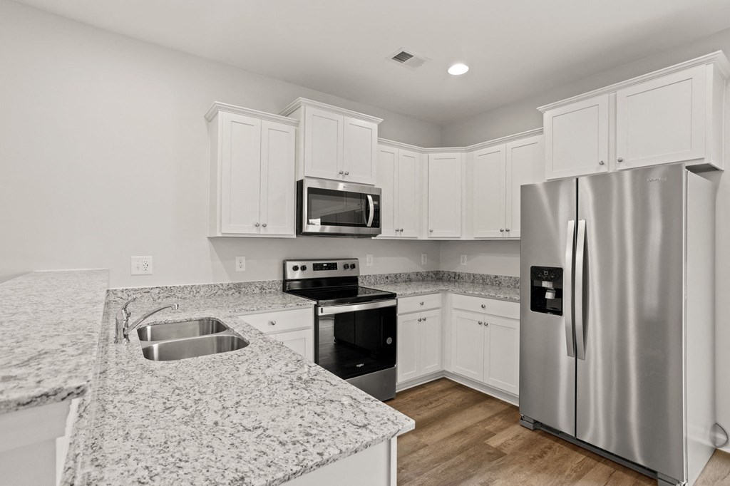 a kitchen with granite counter tops and stainless steel appliances
