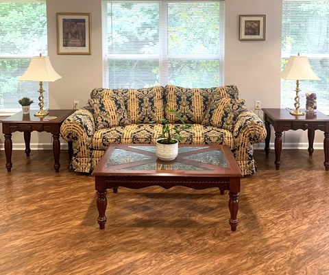 A living room with a patterned sofa and a wooden coffee table.