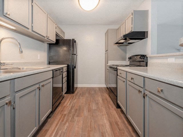 A kitchen with wooden floors and stainless steel appliances.