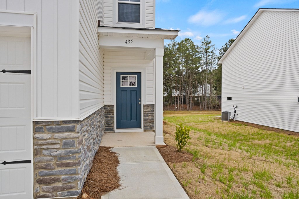 the front of a white house with a blue door