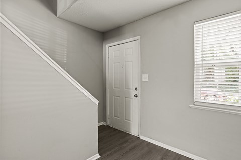 A white door is in a room with a window.