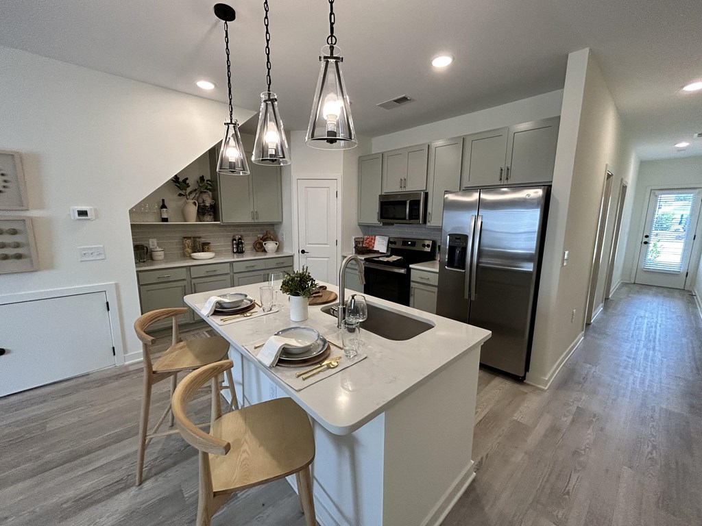 a kitchen with a center island and a stainless steel refrigerator