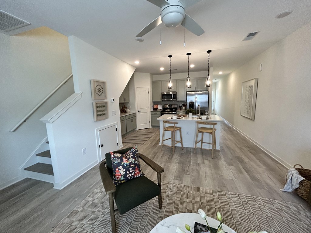 the view from the living room into the kitchen and dining area