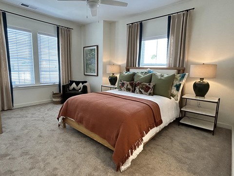 a bedroom with a bed and two windows