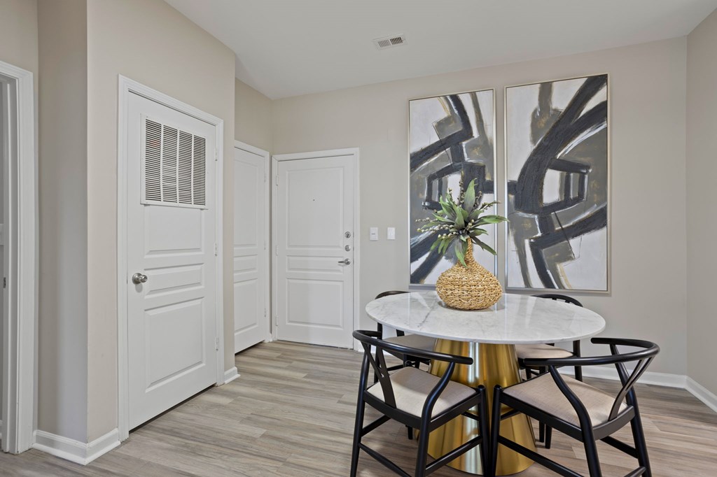 Flatiron West Trade Apartments interior model unit with chairs, small table and pineapple shaped desk pot