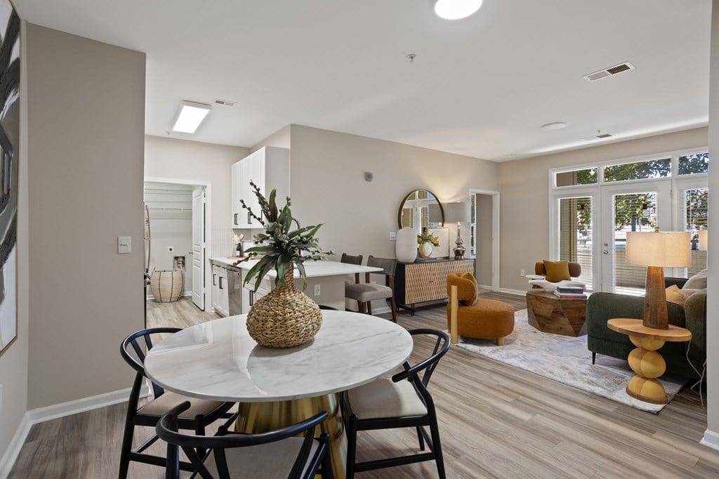 Flatiron West Trade Apartments staged model unit kitchen connected to living room with stainless steel modern appliances and quartz countertops