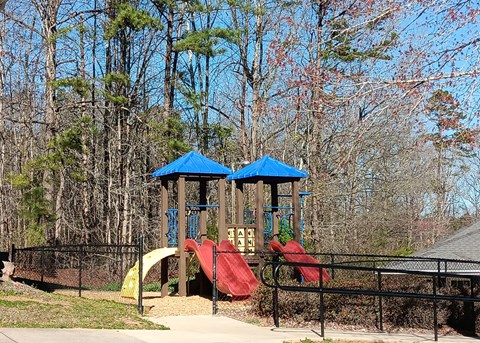 A playground with a blue roof and a red slide.