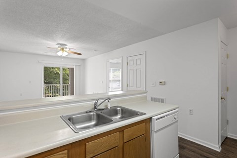 A kitchen with white cabinets and a window.