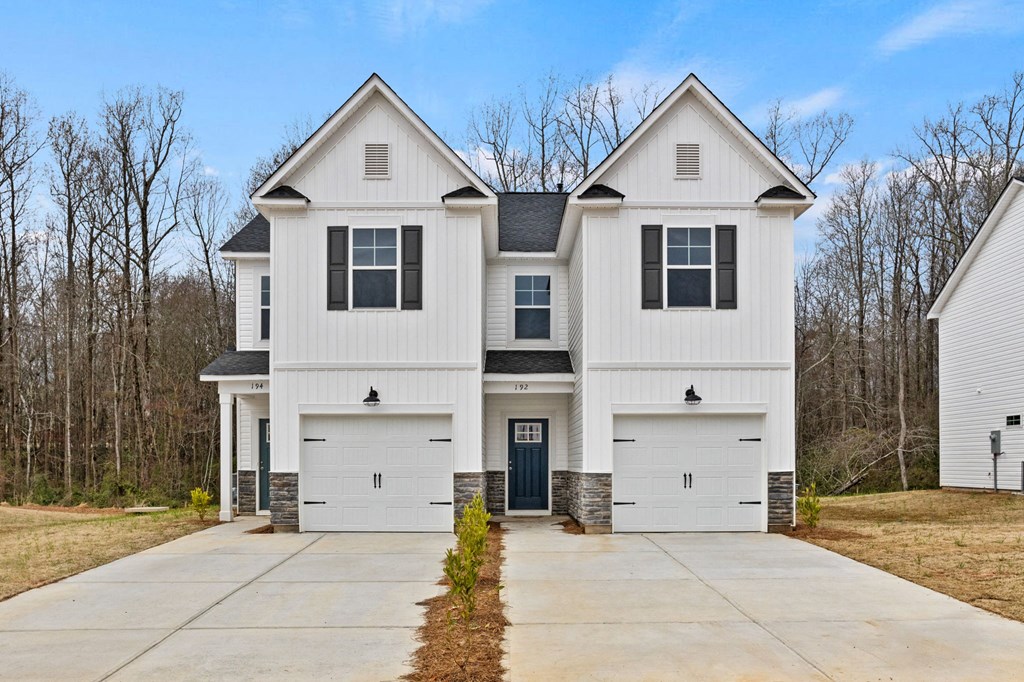 a white house with black shutters and a driveway