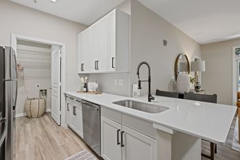 A modern kitchen with white cabinets and a white countertop.