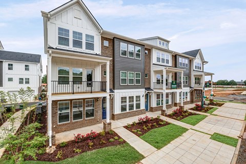 A row of townhouses with a mix of grey and white exteriors.