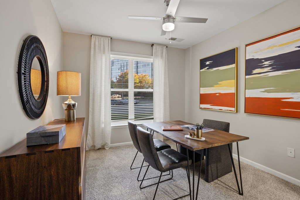 Flatiron West Trade Apartments staged model unit home office with gray carpet and dark wood furniture