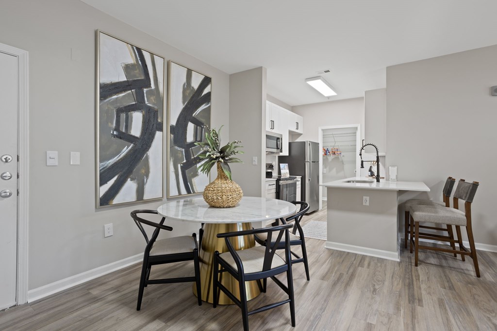 Flatiron West Trade Apartments staged model unit kitchen connected to living room with stainless steel modern appliances and quartz countertops