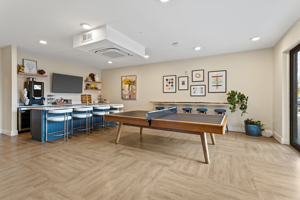 Kitchen space in clubhouse of Park View Greer Apartments in Greer, SC featuring a ping pong table, coffee machine, a granite countertop and a television