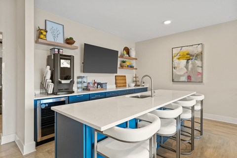 A modern kitchen with blue cabinets and white countertops.