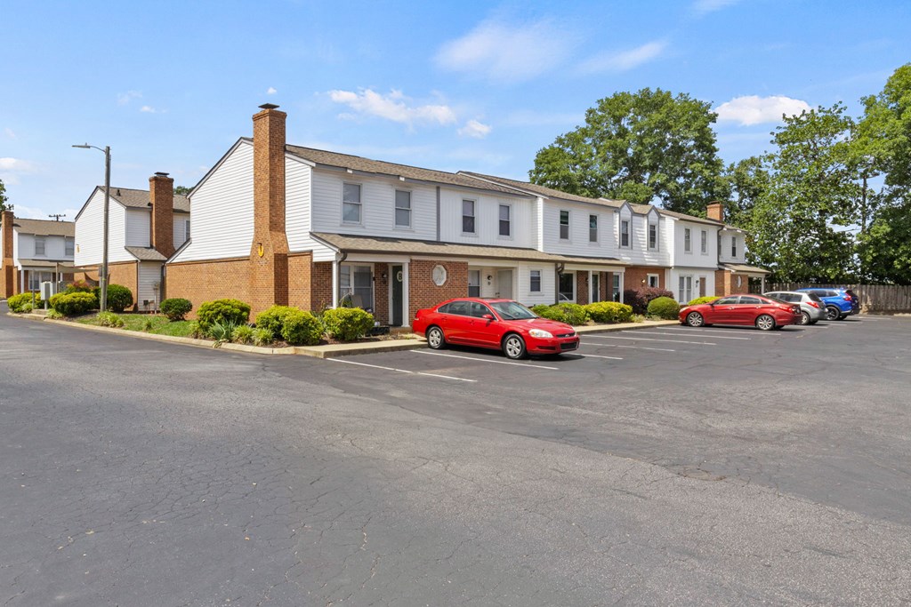 A parking lot with a building and cars in front.