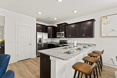 A kitchen with brown cabinets and a granite countertop.