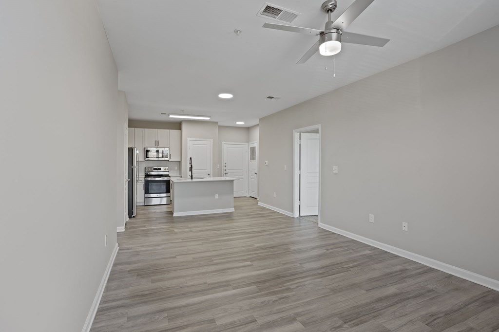 Flatiron West Trade Apartments unstaged model unit with quartz countertops, stainless steel appliances and a large living room.