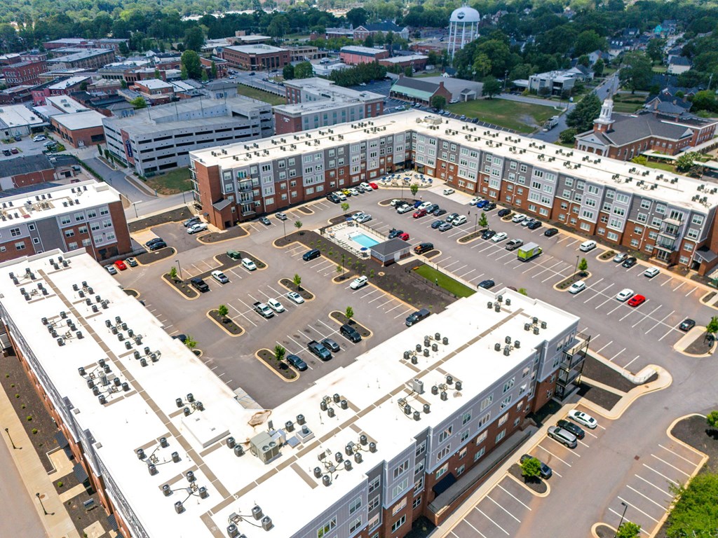 Overhead view of Park View Greer Apartments in Greer, SC, featuring a parking lot and a pool in the middle.