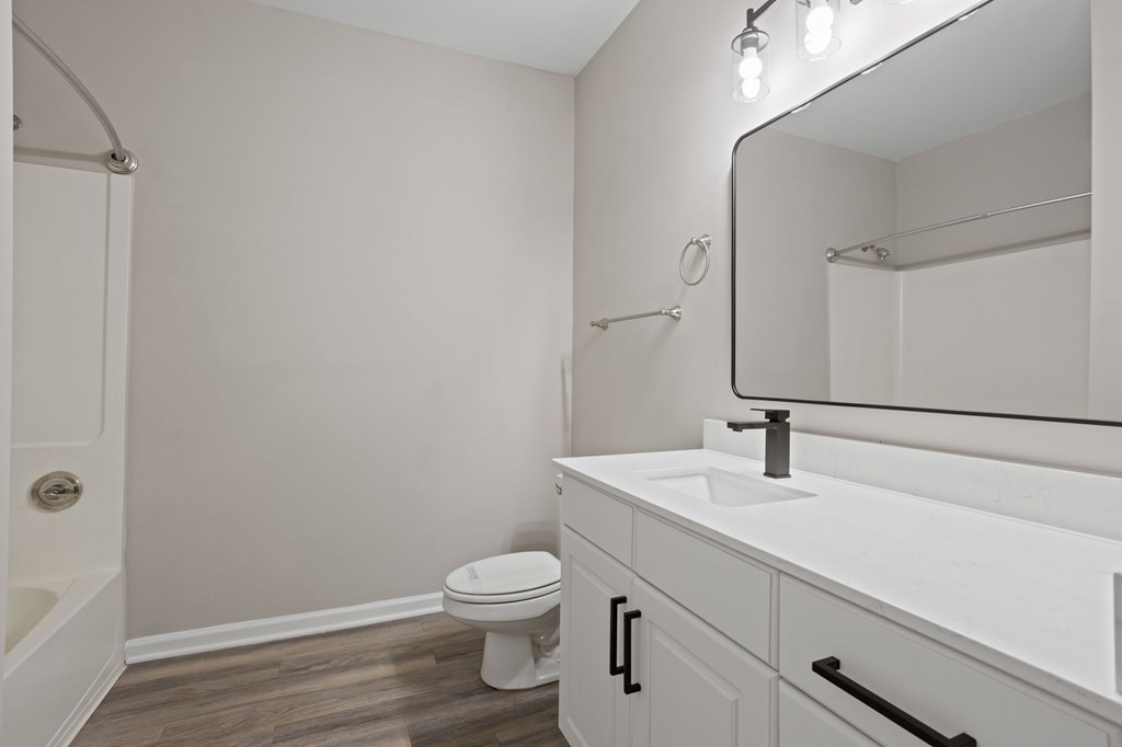 Flatiron West Trade Bathroom with Quartz sinktops and luxury vinyl tile flooring