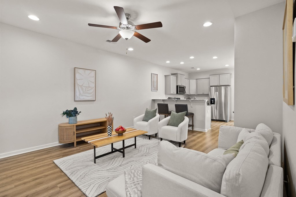 a living room with couches and a ceiling fan