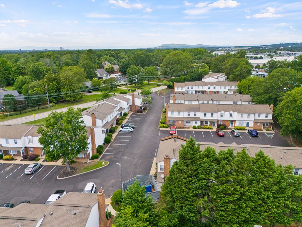 A bird's eye view of a parking lot with cars and buildings.