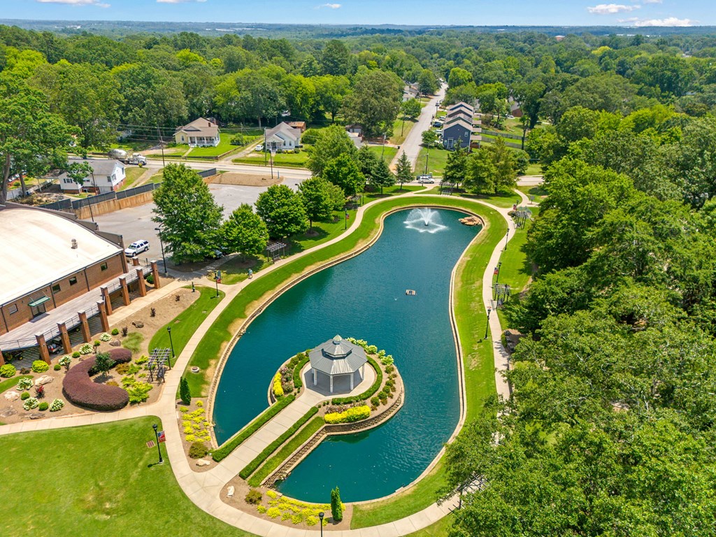 A serene landscape with a pond and a gazebo.