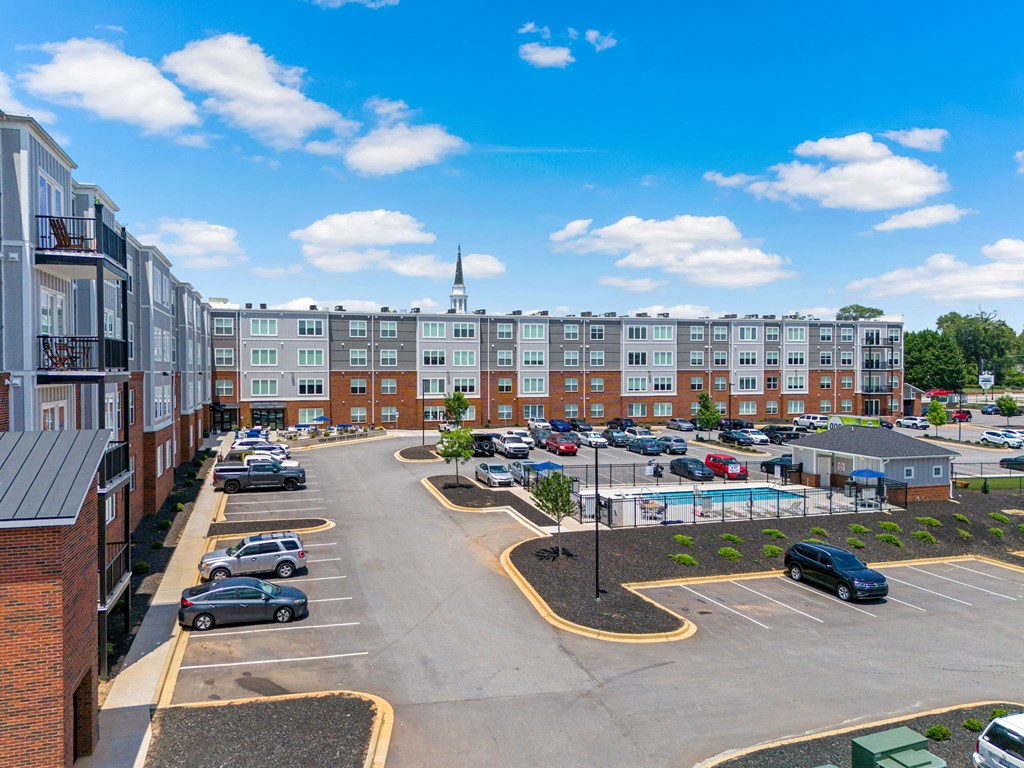 Overhead view of parking lot in Park View Greer Apartments in Greer, SC, with a pool in the middle.
