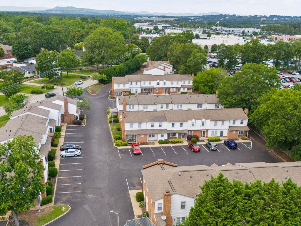 A parking lot in front of a building surrounded by trees.