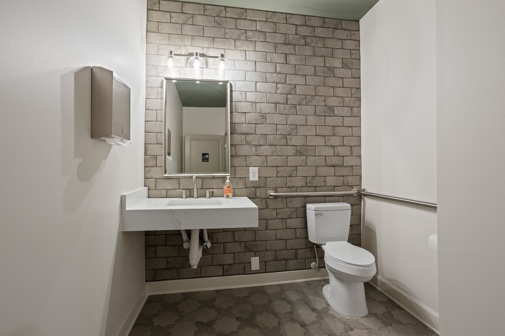 Flatiron West Trade Apartments office bathroom with stone wall