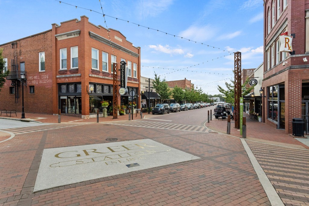 Downtown Greer, SC city square, with brick streets and a gold engraving on the ground which reads "Greer Station."