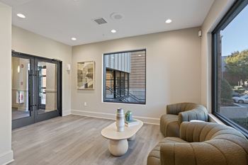 A modern living room with a white coffee table and brown couches.