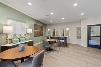 A modern dining room with a wooden table and grey chairs.