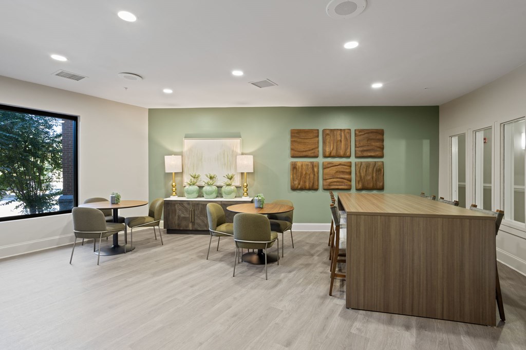 Flatiron West Trade Apartments community room with two small tables and one large community table.