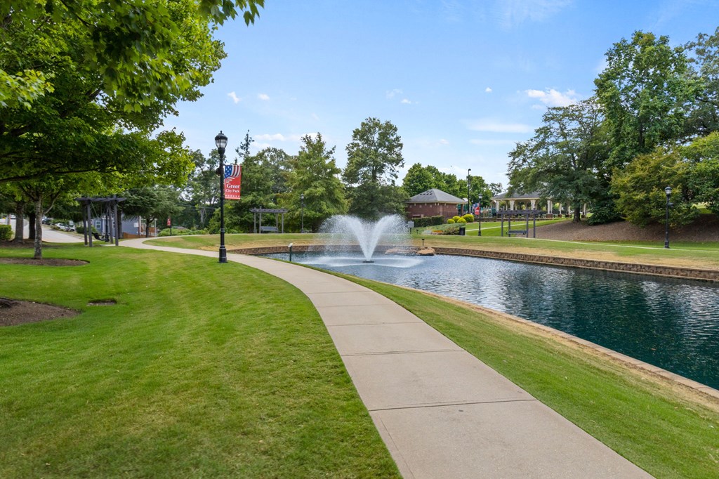 A park with a fountain and a flag.